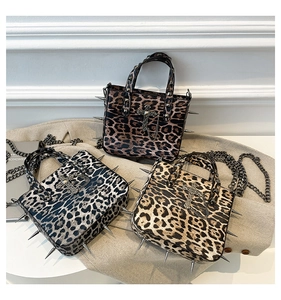 Detail of leopard print tote bags featuring metal studs and cross pendant decoration