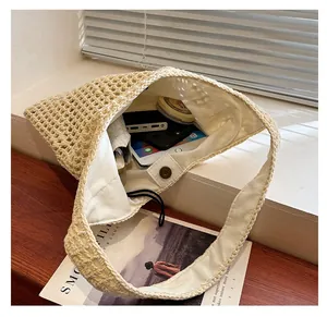 Detail of beige hand-woven tote bag with cotton lining and magnetic metal buckle