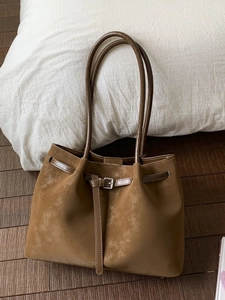 Brown suede tote bag with dual straps and buckle detail for autumn commute wear