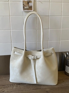 Minimalist cream suede tote bag with decorative silver buckle and long shoulder handles