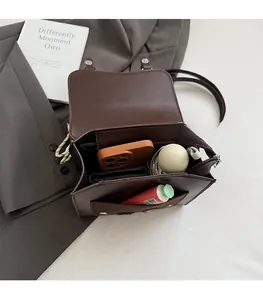 Internal view of brown leather shoulder bag showing compartments for phone and daily items