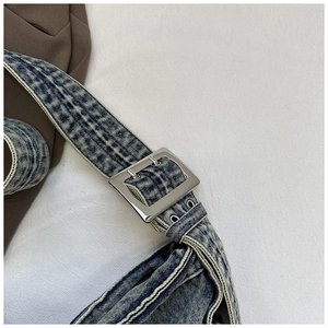 Detailopname van de gewassen denim tasriem met zilveren metalen gesp en vintage textuur