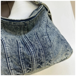 Detailopname van gewassen denim stof met verticale stiksels op deze blauwe draagtas