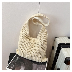 Close-up of the beige crochet hollow mesh texture and inner lining of the woven tote bag
