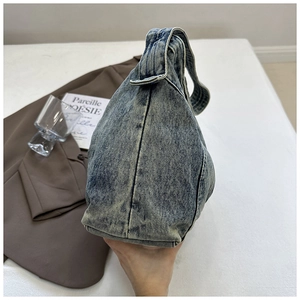 Detail van vintage gewassen denim textuur op een grote schoudertas voor dames