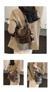Detail of dark brown bucket bag with woven handle and plush rabbit charm accessory