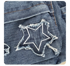 Macro detail of denim backpack showing star patch with frayed edges and orange stitching