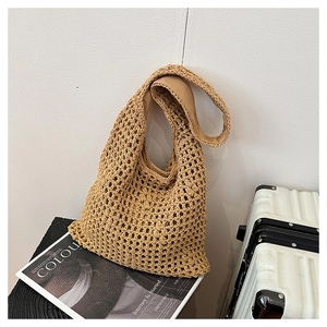 Detail of khaki woven tote bag showing large mesh hollow texture and fabric shoulder strap