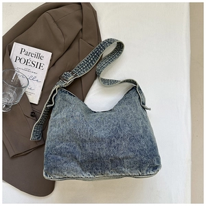 Detail van de verstelbare denim schouderriem met metalen gesp op de blauwe tas