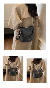 Macro detail of dark grey retro bucket bag with woven chain strap and plush bunny charm