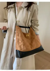 Detail of caramel suede tote with black leather trim and golden metal turn-lock closure