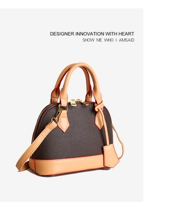 Détail d'un sac à main bicolore avec doubles fermetures dorées et bords peints en rouge