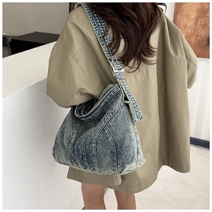 Detail van vintage blauwe denim hobo tas met stiksels en verstelbare metalen gesp