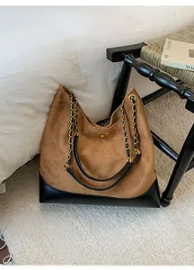 Detail of suede bucket bag with diamond stitching, gold chain strap and metal lock