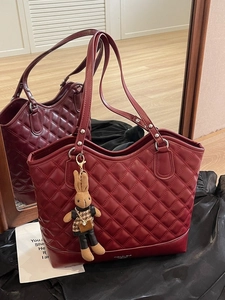 Burgundy quilted tote bag with rabbit charm and classic diamond pattern texture