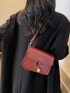 Sac bandoulière classique bordeaux en cuir brillant avec pendentif doré élégant