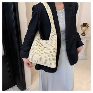 Detailed close-up of cream woven shoulder bag with intricate hollow mesh knit pattern