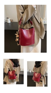 Close-up of vintage burgundy leather bucket bag with woven handle and rabbit charm detail