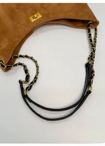Close-up of caramel suede tote with quilted texture and gold-tone chain strap