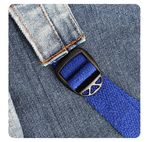 Detail of blue denim backpack showing orange double stitching and black adjustable buckle