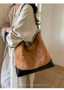 Detail view of suede quilted tote bag with golden twist lock and chain strap