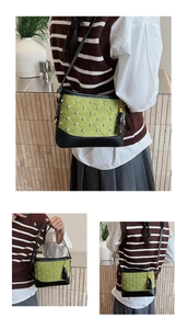 Détail du sac seau vert avec surpiqûres en losange et pompon en cuir noir élégant