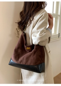 Detail of hobo bag showing brown suede texture, diamond stitching and gold chain