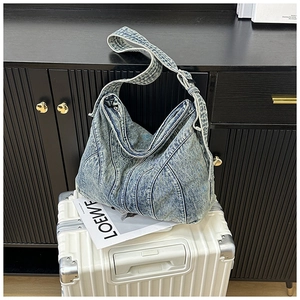 Detail van vintage denim draagtas met contraststiksels op minimalistische koffer
