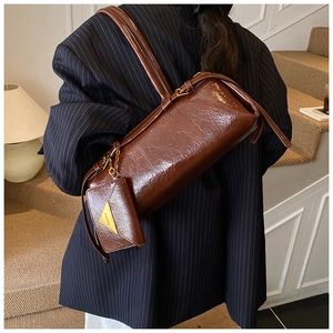 Détail du sac baguette vintage en cuir huilé marron foncé avec petite pochette triangle