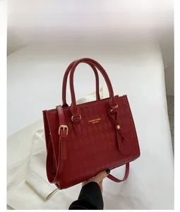 Detail of red quilted rhombus tote bag with gold hardware and leather finish