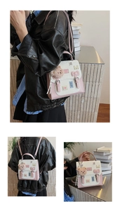 Detail view of pink and white crossbody bag with bow, heart patch and plush bear charm