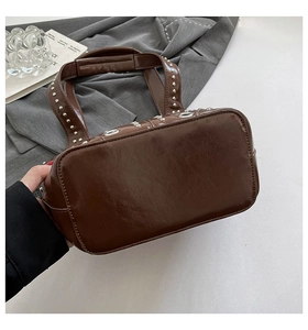 Vue détaillée du grand sac cabas marron foncé avec clous métalliques et cuir texturé