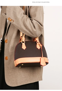 Sac à main rétro marron de style Alma avec détails dorés porté par un mannequin élégant