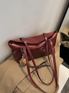 Minimalist burgundy oil wax leather tote bag with baseball glove charm on khaki blazer