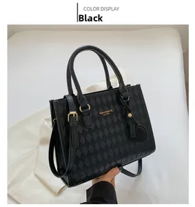 Detail of black quilted shoulder bag featuring gold hardware and a heart-shaped charm