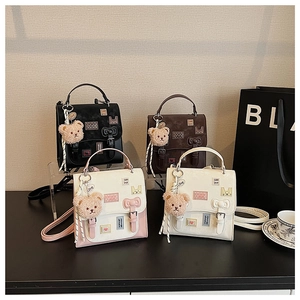 Detail of four stylish cross-body bags with cartoon patches and bear charms in a set