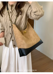 Detailed close-up of quilted suede and leather tote bag with elegant gold twist lock