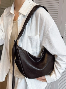 Minimalist faux leather crescent shoulder bag with zipper and decorative straps for women