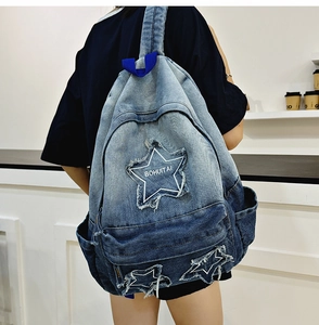 Detail of star patchwork and distressed denim texture on a gradient canvas backpack