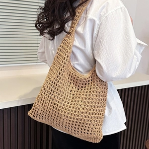 Hollow woven tote bag with shoulder strap and inner lining shown on a model
