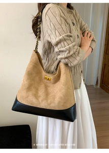 Detail of quilted suede tote with gold metal twist lock and leather chain strap