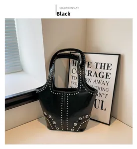 Détail du sac à main noir en cuir avec rivets argentés et œillets métalliques