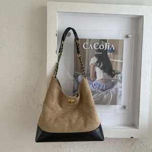 Detail of khaki suede tote with diamond quilting and gold rotating metal buckle