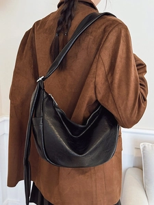 Minimalist black crescent moon shoulder bag with soft leather texture and sleek wide strap