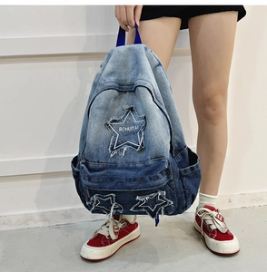 Detail of vintage gradient denim backpack featuring a star patch and BOHUITAI logo