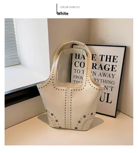 Vue détaillée du sac à main blanc à rivets avec finition brillante et clous en métal