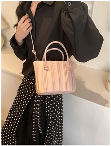 Détail du sac à bandoulière plissé rose clair avec poignée perlée et bandoulière