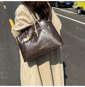 Détail d'un grand sac cabas marron rétro avec logo Muon SharK et pendentif baseball