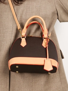 Sac à main rétro bicolore marron et beige avec bandoulière sur un manteau en laine
