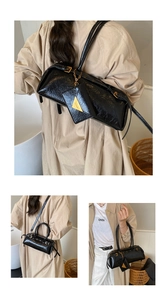 Détails du sac en cuir brillant noir avec garnitures dorées et pendentif de mode